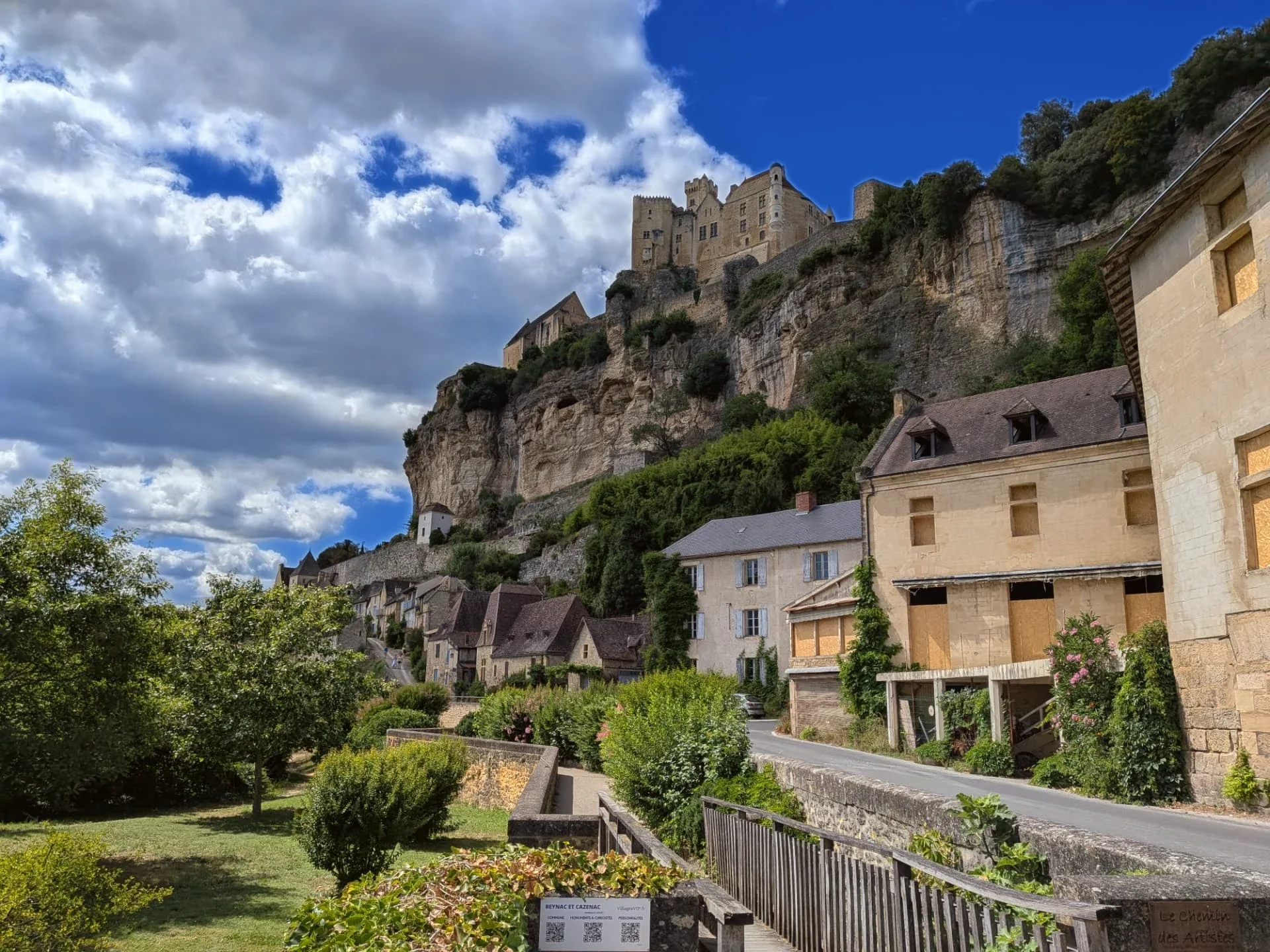 The riverside path at Beynac with village houses climbing towards the château on the cliff
