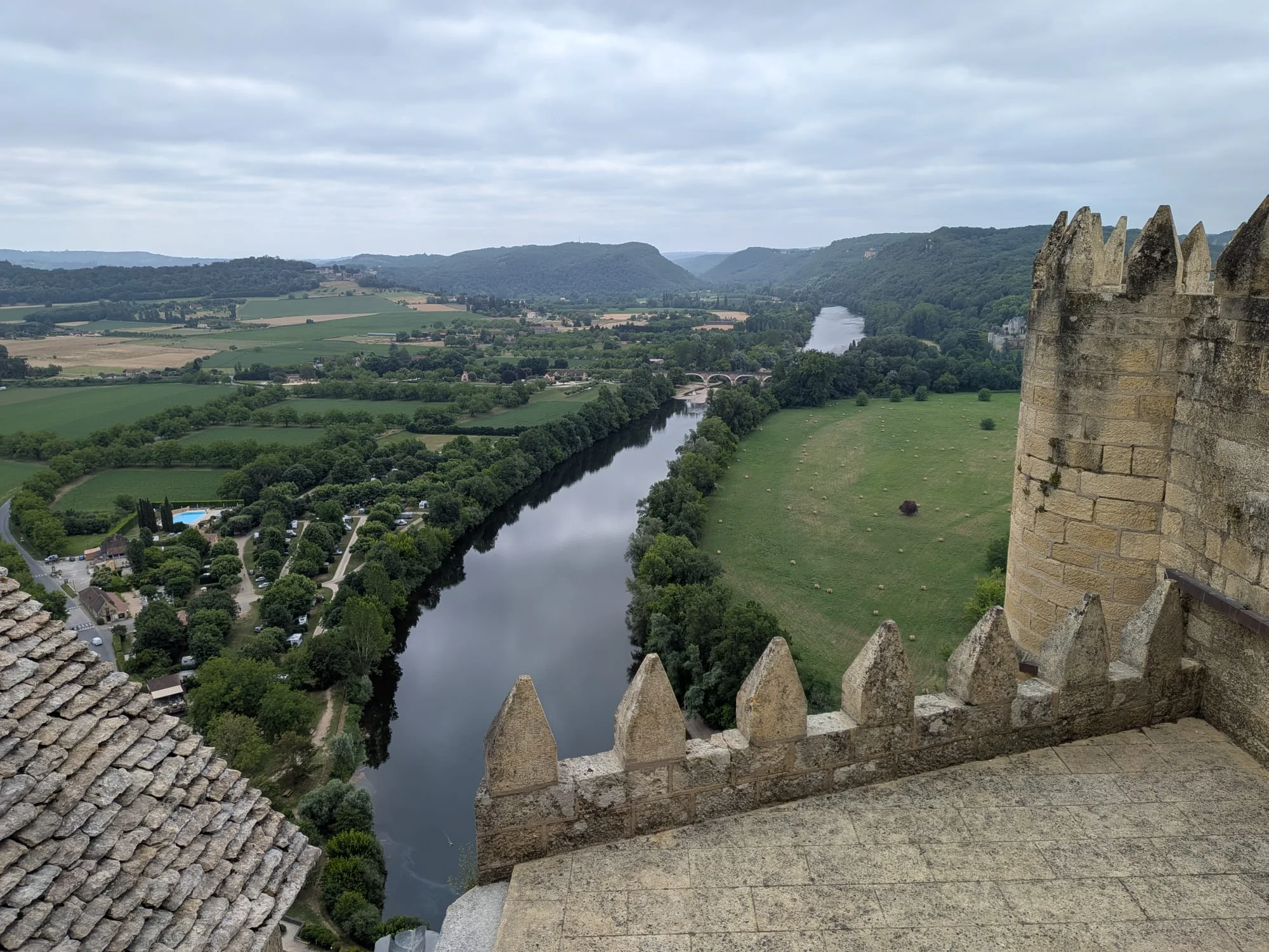 View from the ramparts of Château de Beynac down to the Dordogne and the valley under a cloudy sky