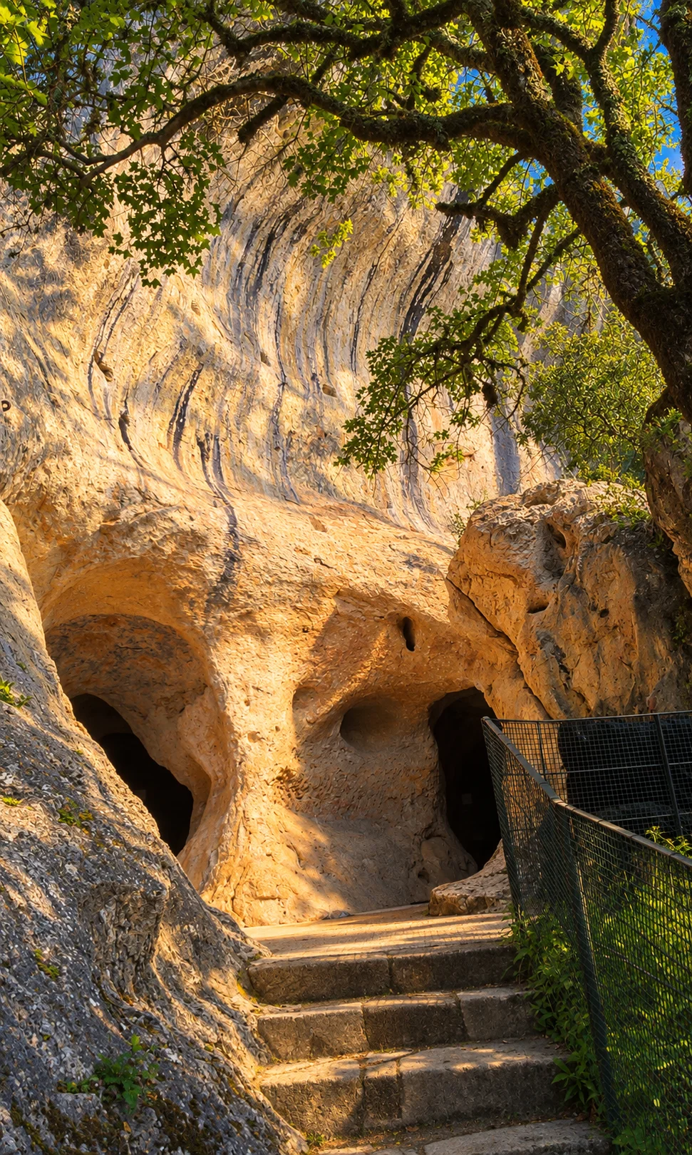 Font-de-Gaume cave, re-rendered from an openly licensed photo (Summer · Deep brochure blue · Golden hour)