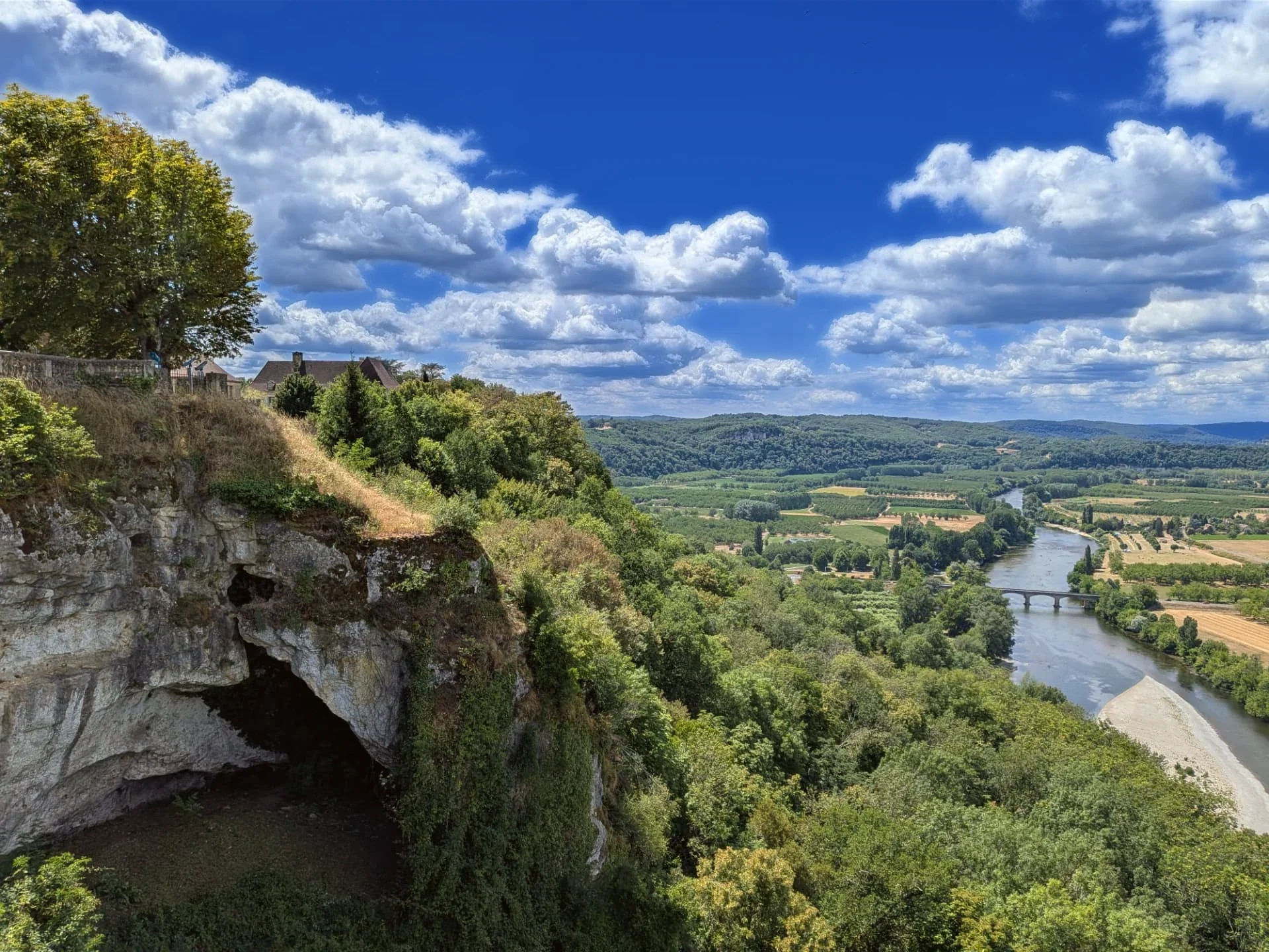 Cliff edge and rock overhang below the belvedere at Domme, with the river beyond