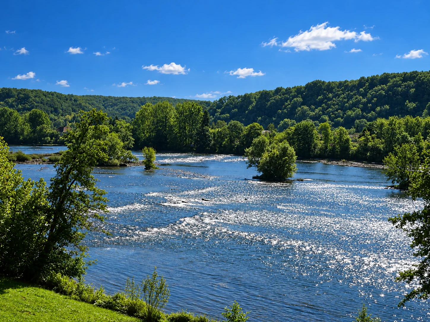 Sunlight reflects off the Dordogne around small wooded islands at Lalinde.