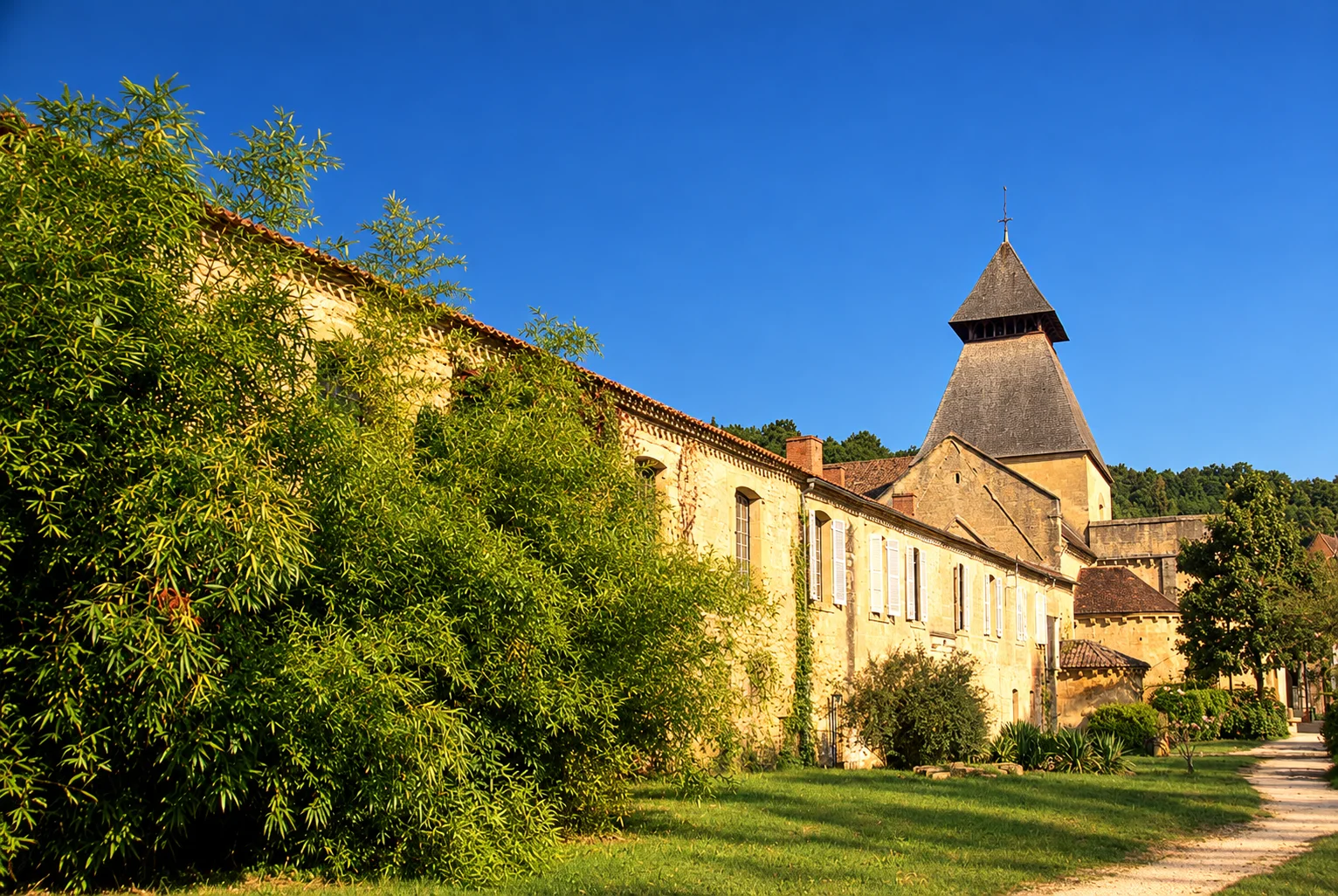Cadouin Abbey, re-rendered from an openly licensed photo (Summer · Deep brochure blue · Golden hour)