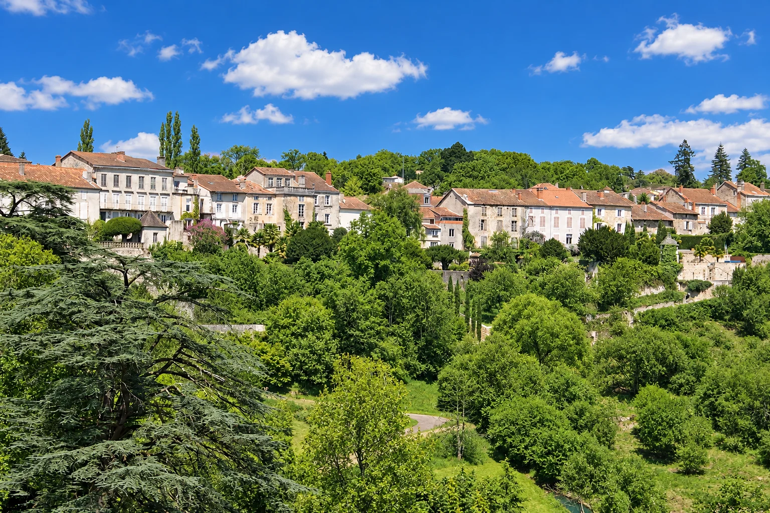 Stone houses overlook terraced gardens and mature trees in Nontron.